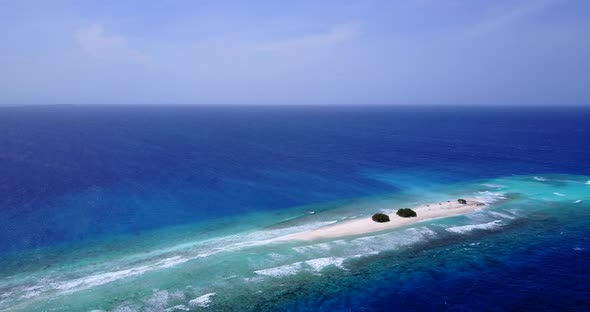 Tropical birds eye abstract shot of a white sandy paradise beach and blue ocean background in 4K alt