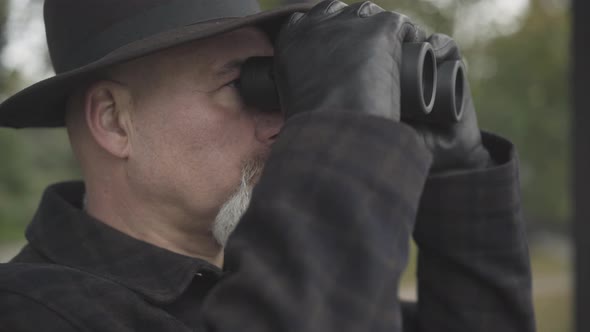 Close-up of Bearded Professional Detective or Spy Tracking Someone Outdoors. Elegant Caucasian Spy alt