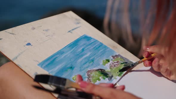 Drawing Seascape By Aquarelle Woman is Practicing Her Creative Hobby alt