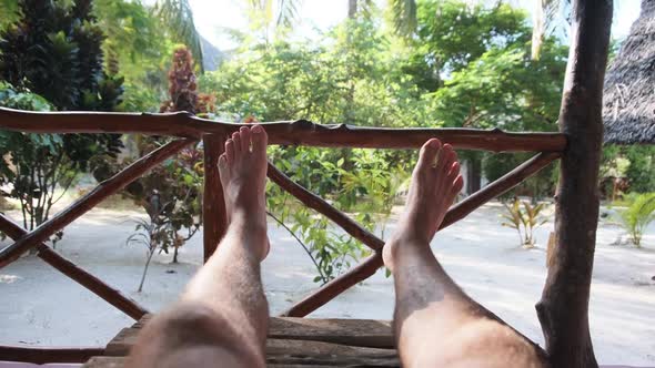 POV of Man Legs on the Tropical Hotel Veranda Summer Vacation Zanzibar Africa alt