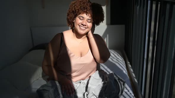 Beautiful Curvy Plus Size African Black Woman Afro Hair on Bed with Grey Plaid Blanket Cozy Bedroom