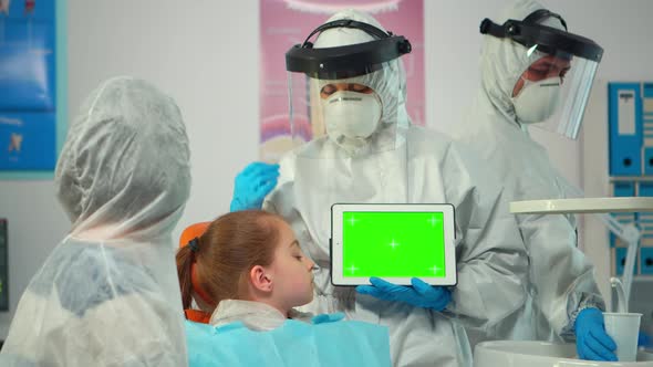 Stomatologist with Coverall Pointing at Mockup Greenscreen Display alt
