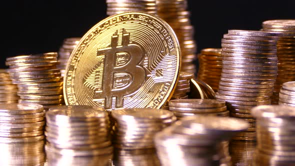 Bitcoin on the Background of a Pile of Gold Coins