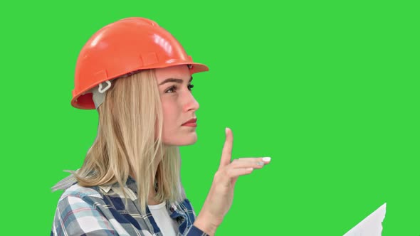 Pretty Young Engineer Woman Examining Draft Plans Analyzing Scheme Project Design on a Green Screen alt