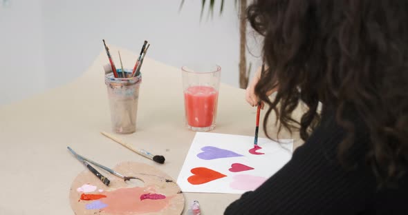 Unrecognizable Girl Drawing Hearts on Paper for Saint Valentine's Day