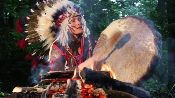 Woman Dressed in Shaman Costume Playing on Shaman Drum