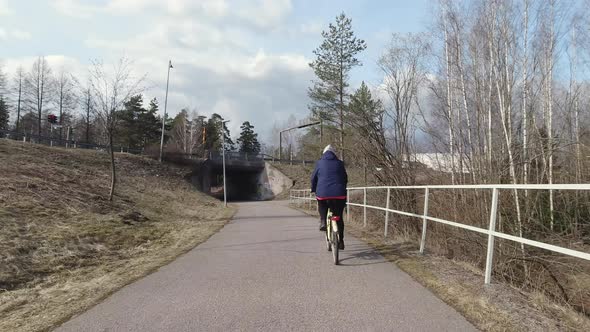 The Middleaged Lady on Her Bicycle on the Streets in Vantaa Finland