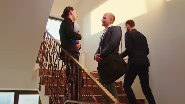 Business Partners Standing on Busy Staircase Talking alt