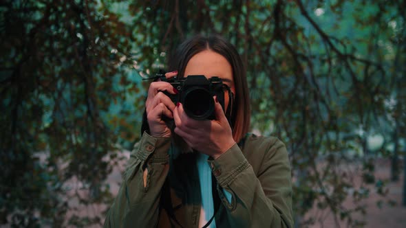 Girl in nature taking frontal photo looking at camera, Close-up portrait, handheld alt