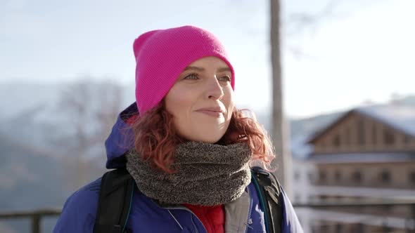 Portrait of a Woman in a Pink Hat and Blue Jacket Standing and Smiling