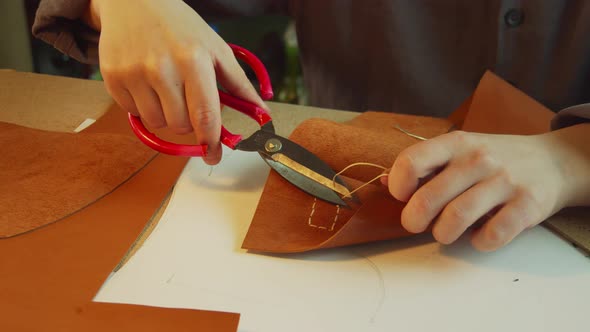An Experienced Tanner in the Process of Creating a Women's Handbag. Cuts Off the Excess Sartorial alt