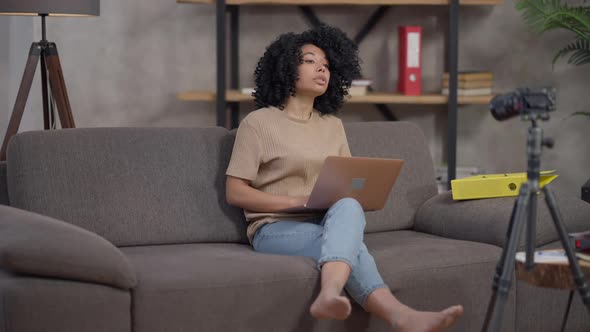 Professional African American Business Consultant Recording Video Blog Typing on Laptop Keyboard alt