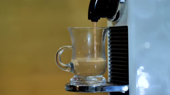 Automatic Coffee Machine or Coffeemaker Pouring Espresso Coffee at Home in A Glass Cup