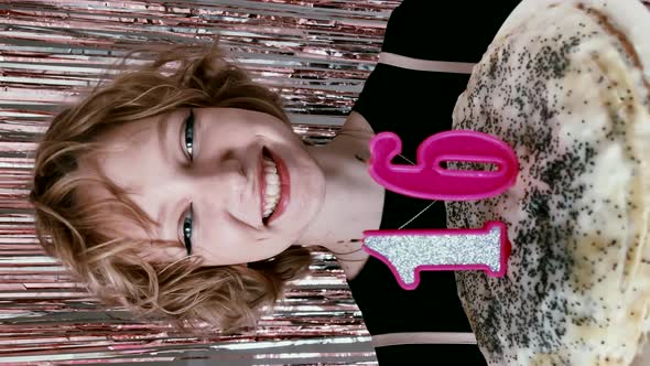 charming girl with closed eyes making a wish and blowing out candles on a birthday cake alt