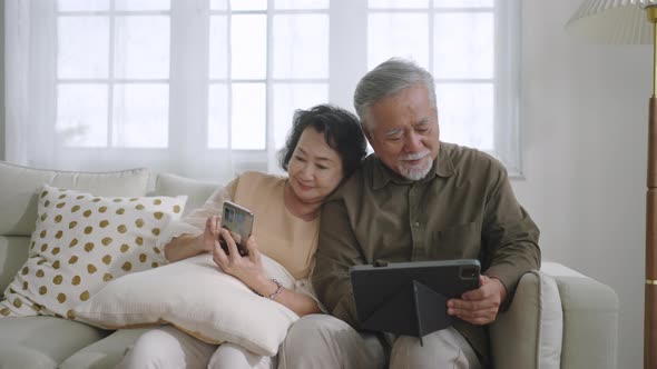 Asian senior couple in living room at home.