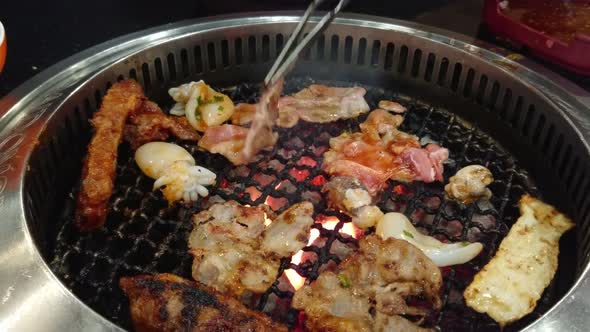 Pork and squid are grilled on the grill.