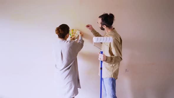 Young Woman in Shirt Puts Colour Templates on Brown Wall
