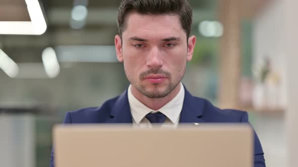 Close Up of Focused Businessman Working on Laptop  alt