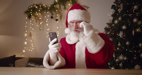 Portrait of a Frustrated Santa Claus Swiping on Websites Browsing Surfing on Internet Web Pages Then alt
