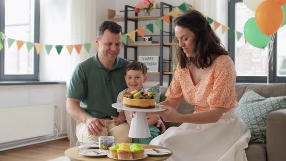 Happy Family with Birthday Cake at Home Party alt