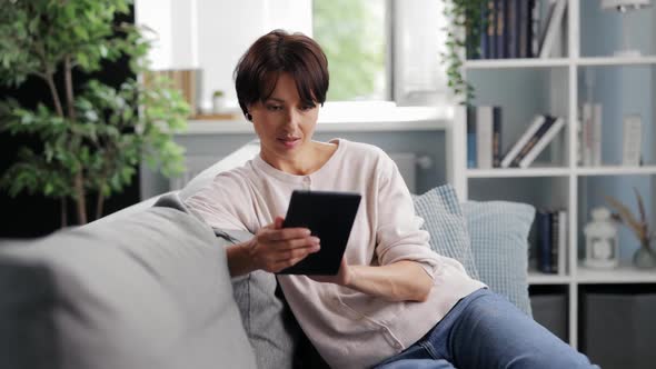 Satisfied Woman with Tablet at Home