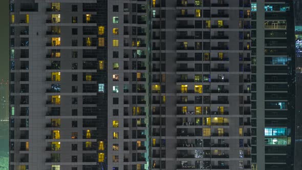 Windows of the Multistorey Building of Glass and Steel Lighting Inside and Moving People Within alt