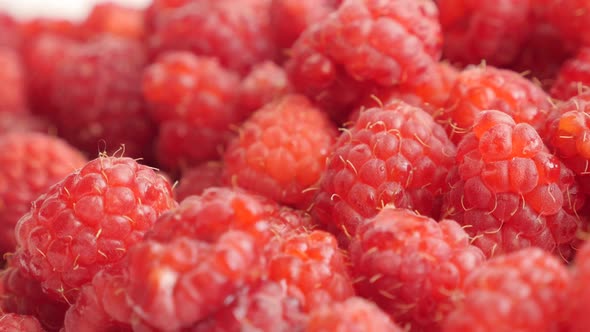 Backgroung of Rubus idaeus healthy fruit on pile close-up 4K 3840X2160 UHD tilting video - Slow tilt alt