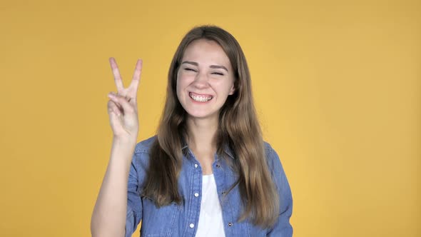 Victory Sign By Pretty Woman Isolated on Yellow Background alt