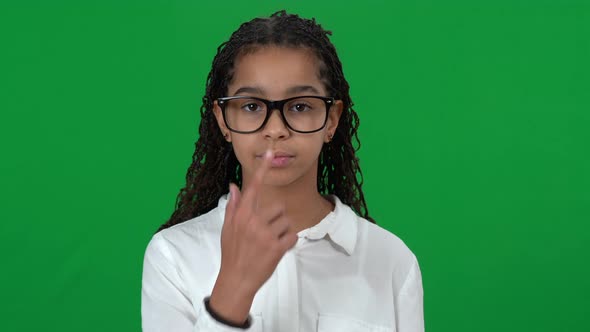Confident African American Nerd Teen Adjusting Eyeglasses Smiling Looking at Camera on Green Screen alt