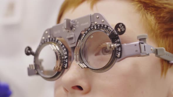 Close Up of Little Boy Having Eye Vision Test with Trial Frame alt