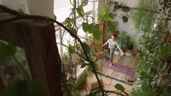 High Angle of Woman Doing Extended Hand-To-Big-Toe Pose during Yoga Practice alt