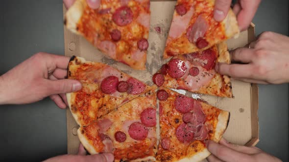 Male Hands Taking Slices of Pizza With Cheese Tomatoes and Ham From Food Delivery