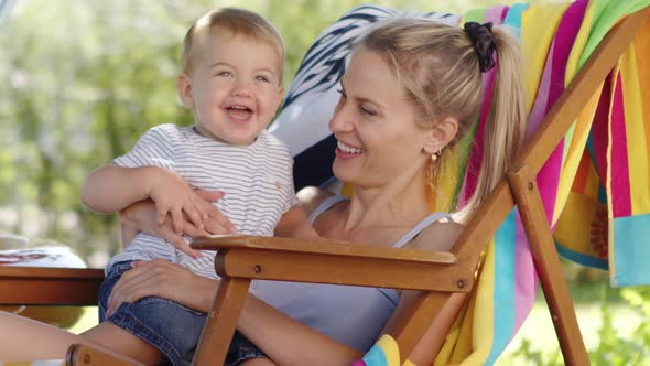 smiling and happy mother hugging and cuddling her baby son, child enjoys kissing mom, together sitti alt