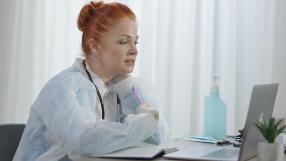 Side View of Serious Focused Doctor Consulting Patients Online alt