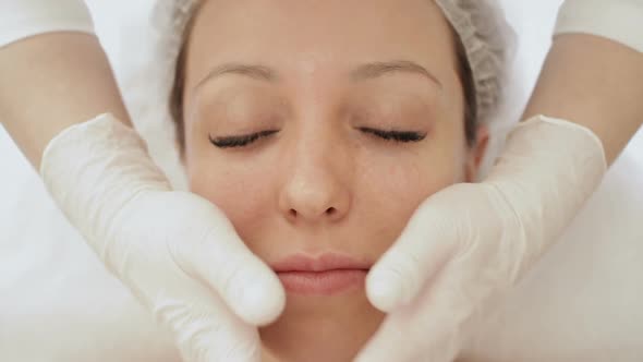 Woman doing facial massage in spa salon