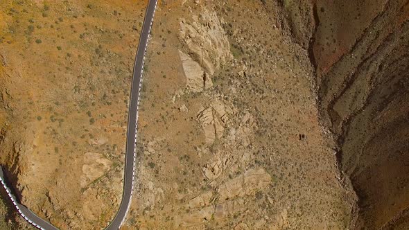 Aerial view of the winding mountain road between two villages of Fuerteventura. alt