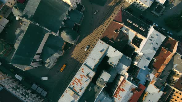 Aerial Top View From Above on the Roofs of Houses and the Street on Which the Car Goes alt