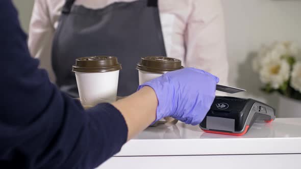 Buyer Takes Two Disposable Cups of Coffee and Pays for the Purchase with a Payment Card alt