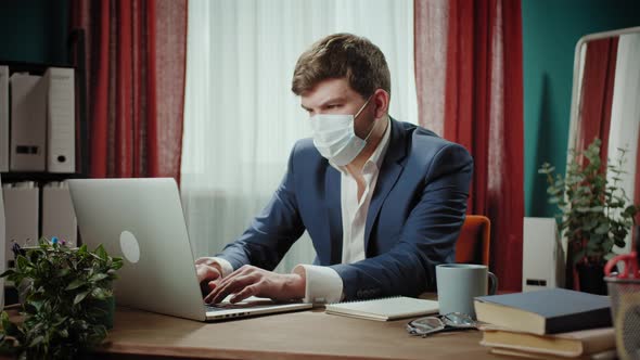 Executive Senior CEO Businessman in Medical Mask Working Online on Laptop Remote Office Man Typing alt
