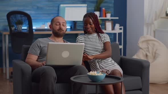 Young Interracial Couple Looking at Modern Laptop alt