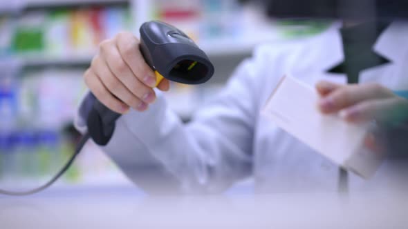 Unrecognizable Pharmacist Cashier Scanning Pills Box with Device Stretching Medication in Slow alt