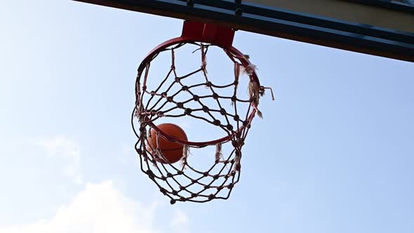 Shooting orange basketball ball into the basket alt