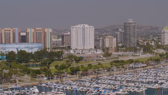 Aerial of boats moored at harbor and beautiful skyscrapers in background alt