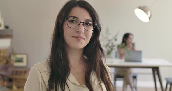 Young Pretty Caucasian Girl in Eyeglasses Looking at Camera and Smiling alt