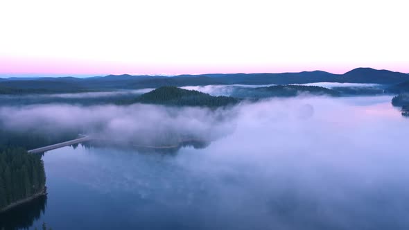Fly over the morning fog over the mountain lake. Rodopi mountain Bulgaria