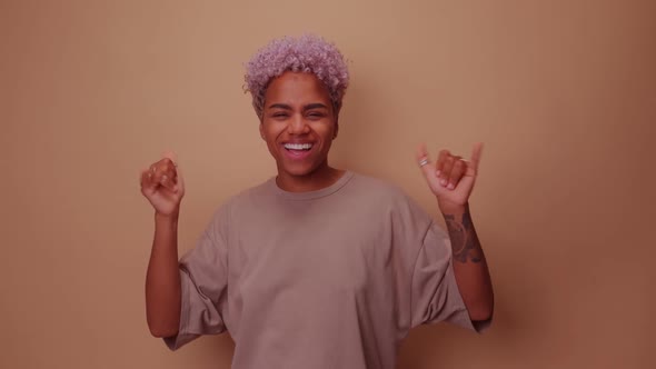 Friendly Looking Positive African American Woman Shows Shaka Sign Gestures alt