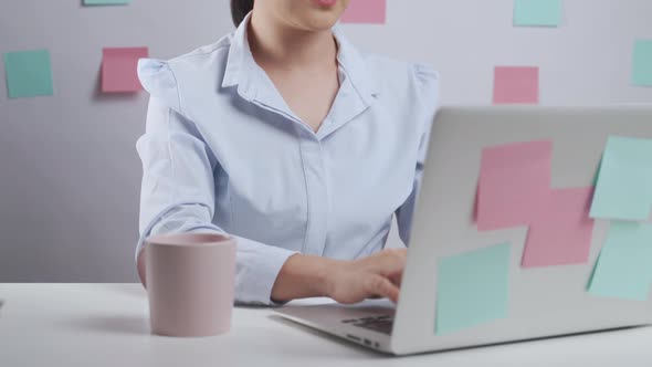 Asian woman working on a laptop was sick with body pain sitting