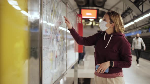 Traveler woman find the best route on interactive info touch screen map at metro station. alt