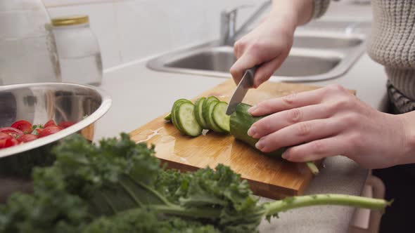 Woman Hands Cutting a Cucumber