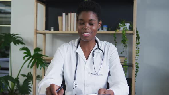Portrait of african american female doctor having a video chat talking and smiling alt
